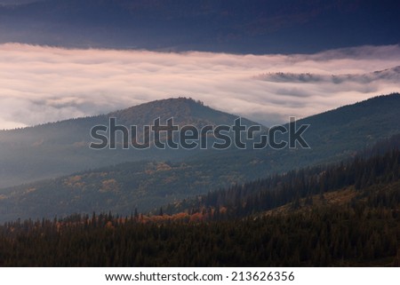 View of a mountain valley in a beautiful early morning with fog between hills.