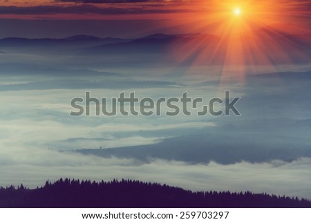 Majestic sunrise in the foggy mountain layers landscape. Soft focus filter. Filtered image: instagram toning effect.