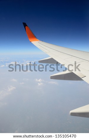 Wing of the plane on sky background  -  view from the window of a plane of the wing, the sky - View of jet plane wing