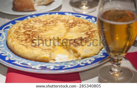 Authentic spanish tortilla. Served at a typical spanish restaurant in Madrid with a glass of beer.