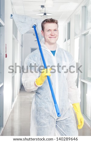 Man cleaning office wearing protective overalls