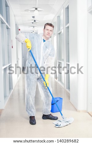 Man cleaning office wearing protective overalls