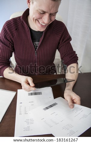 Mobile payment concept casual man paying invoices smiling
