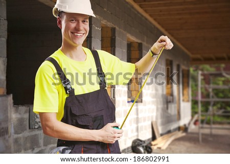 Contractor taking measures smiling at construction site