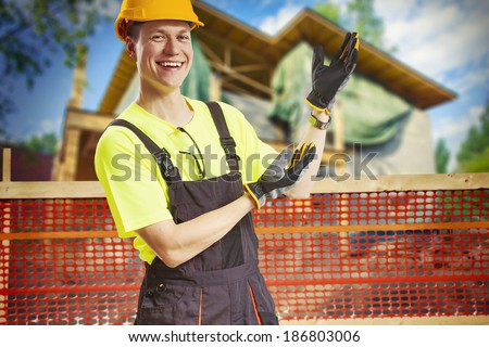 Smiling construction worker showing work in progress at construction site