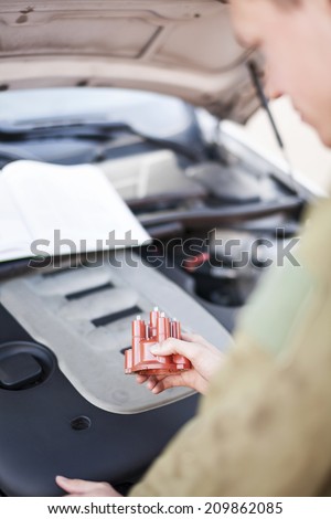 Mechanic reading instructions manual and replacing broken part