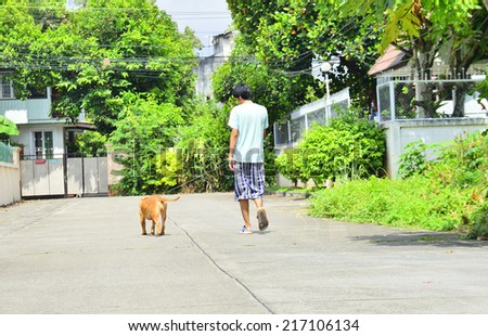 Young man walking with his dog on the street