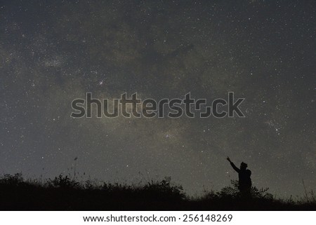 A woman looks into space and the Milky way. Long exposure photograph