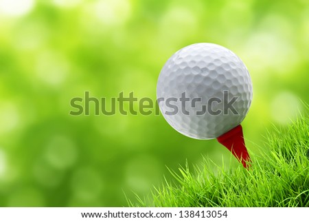 a golf ball on tee on green bury background