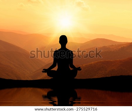 Man meditating in yoga position on the top of mountains