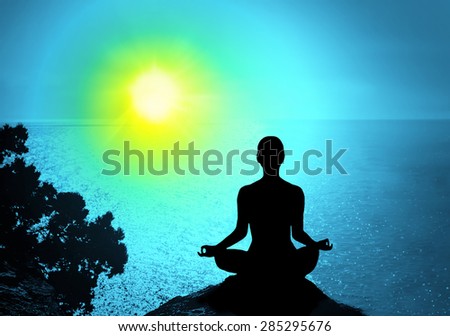 Yoga and meditation. Silhouette of man on the peak of the mountain
