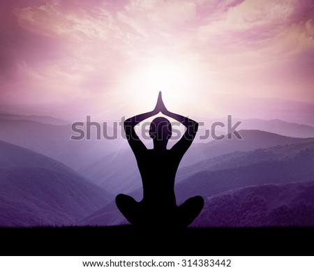 Yoga and meditation. Silhouette of man in the mountains.
