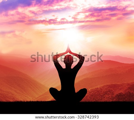 Yoga and meditation. Silhouette of man in the mountain