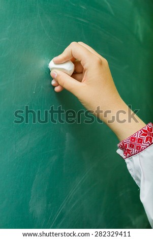 student's hand  wrote on the blackboard with chalk