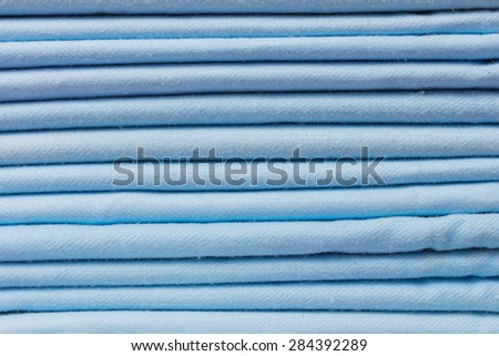 Background of blue fabric folded in a pile close-up.