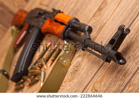 Kalashnikov assault rifles with ammunition on a wooden table