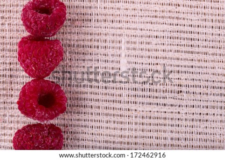 Berries frozen raspberries on texture of linen fabric closeup