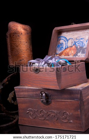 two old vintage chests patterns with a candle and a candlestick on a black background