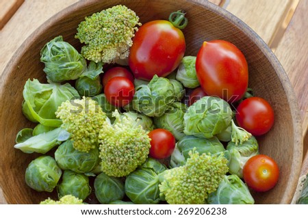 cherry tomatoes, brussels sprouts with broccoli on a wooden table