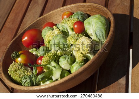 cherry tomatoes, brussels sprouts with broccoli on a wooden table