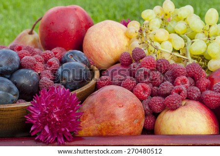 different types of fruit and raspberry closeup with flower aster