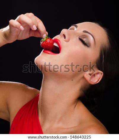 Beautiful woman eating a strawberry