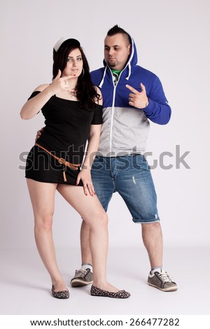 Young couple in rapper clothes posing in the studio