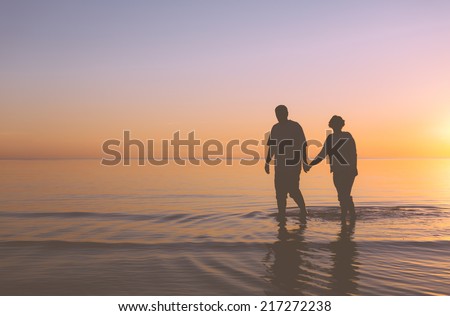 Senior couple walking holding hands at sunset Senior couple walking holding hands at sunset