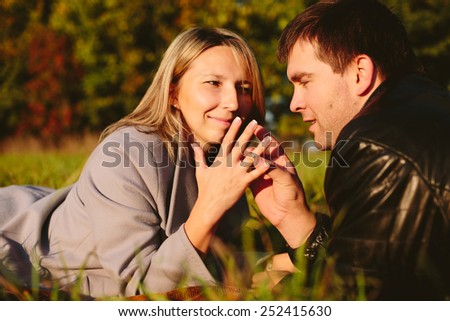 Man tries on ring on a finger girl lying on a meadow in the park