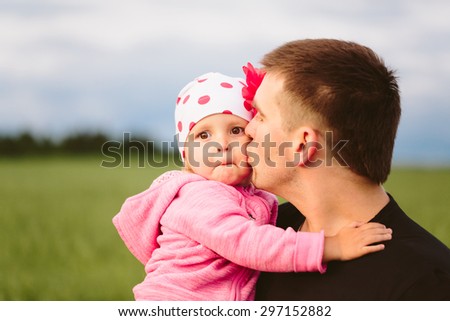 Father kissing his daughter on the cheek Surprised in nature close-up
