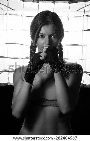 beautiful fitness girl posing in sport outfit. backlit sporting model in bikini black and white