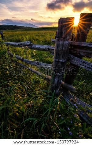 Country fence and pasture at sunset