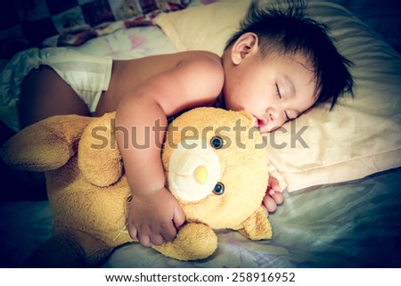 Vintage child sleep with a teddy bear.