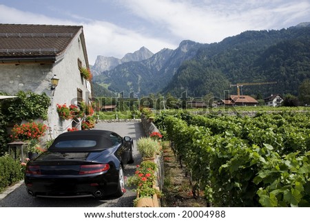 Beautiful Swiss vineyard, typical village house and luxury black car