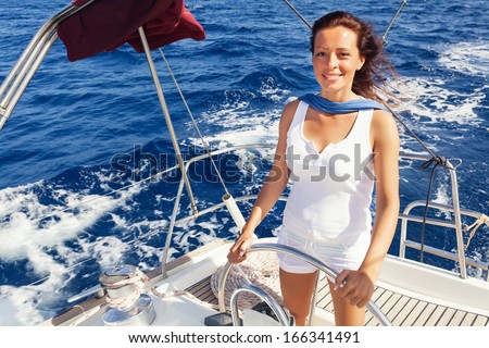 Beautiful lady skipper navigating a sailboat.