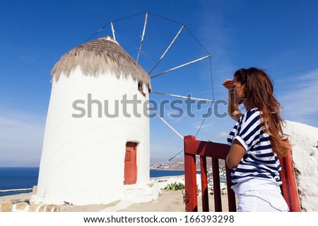 Mid adult woman standing in the front of the windmill and looking away. Mykonos, Greece