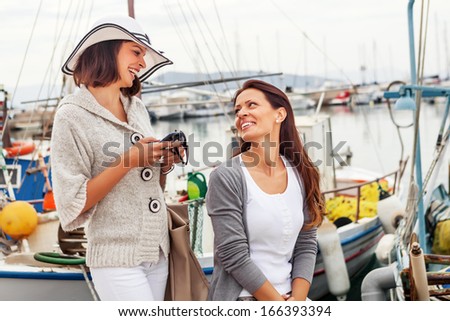 Happy women at the harbor, smiling face to face