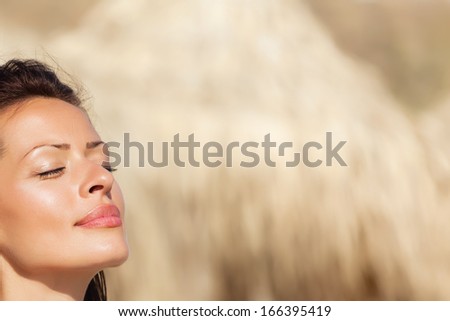 Head shot of beautiful woman enjoying the sunshine at a coast.Copy space