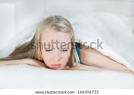Young woman lying in bed and thinking..