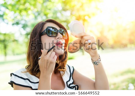 Attractive woman doing make up lip liner
