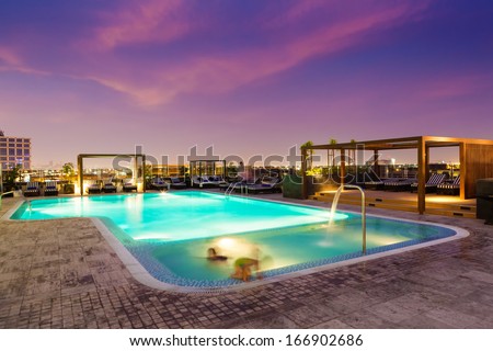 Luxury rooftop swimming pool at sunset, blurred motion