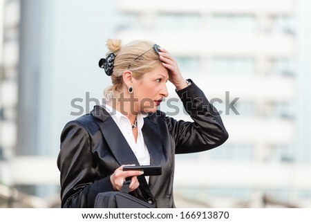 Businesswoman using a mobile phone on the street,bad news, getting a bed news