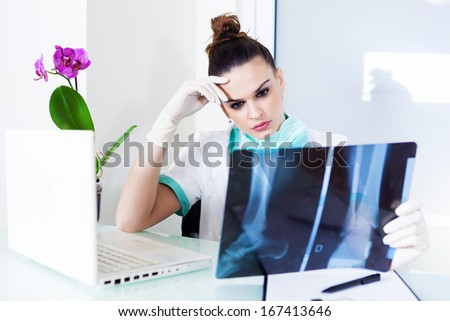 Female doctor looking at X-ray of a leg in her office