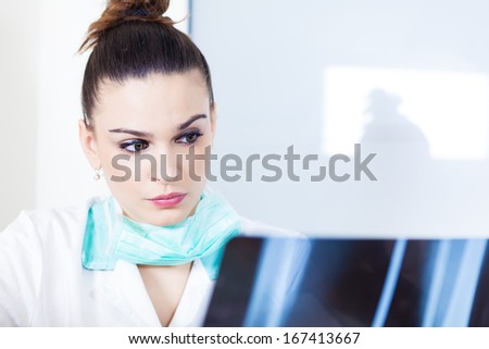 Female doctor looking at X-ray of a leg in her office