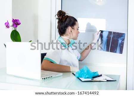 Female doctor looking at X-ray of a leg in her office.