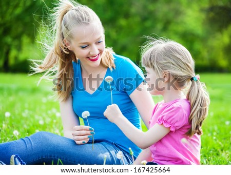Two sisters with a dandelion in the park
