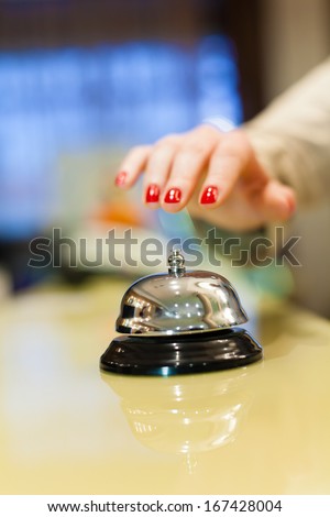 A female hand ringing silver service bell