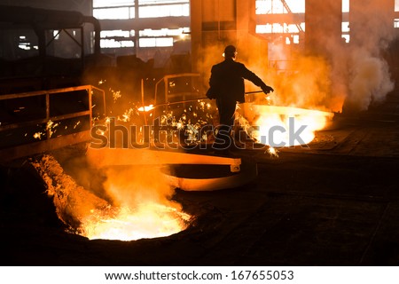 Working In A Foundry. Workers Looking Down, Red Color Is A Reflection Of The Molten Metal. Very High Heat And Purple Fringing. See More Images And Video From This Series.
