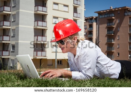 Engineer lying on grass and using a laptop,break time