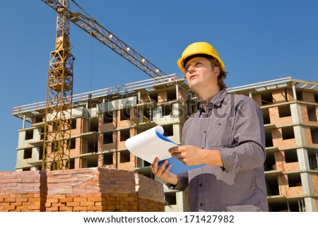 Construction architects review plans at a construction site with crane Construction architects review plans at a construction site with crane